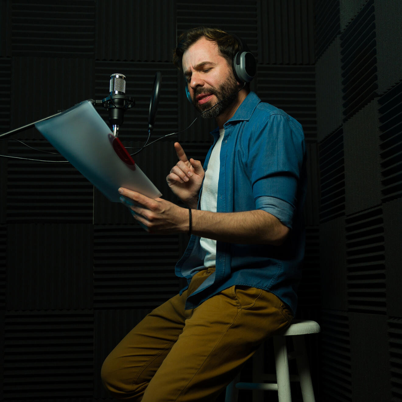 Professional Voice Actor Recording Voiceover in Studio for Commercial and Corporate Projects Professional voice actor recording voiceover audio in a studio for commercial, corporate video and media production